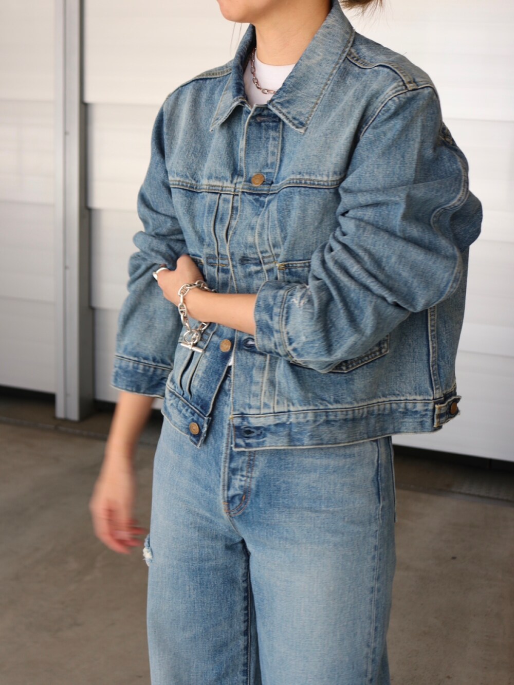 ブルー系のデニムジャケット、グリーン系のその他アウター、ブルー系のデニムパンツを着用したレディースの冬コーディネートの3枚目の写真