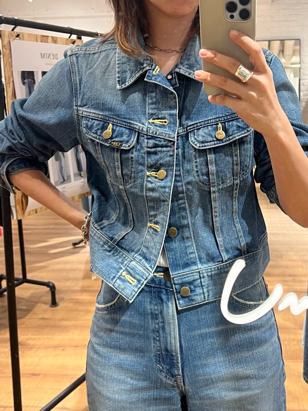 ブルー系のデニムジャケット、ブルー系のデニムパンツ、ホワイト系のパンプスを着用したレディースの夏コーディネートの2枚目の写真