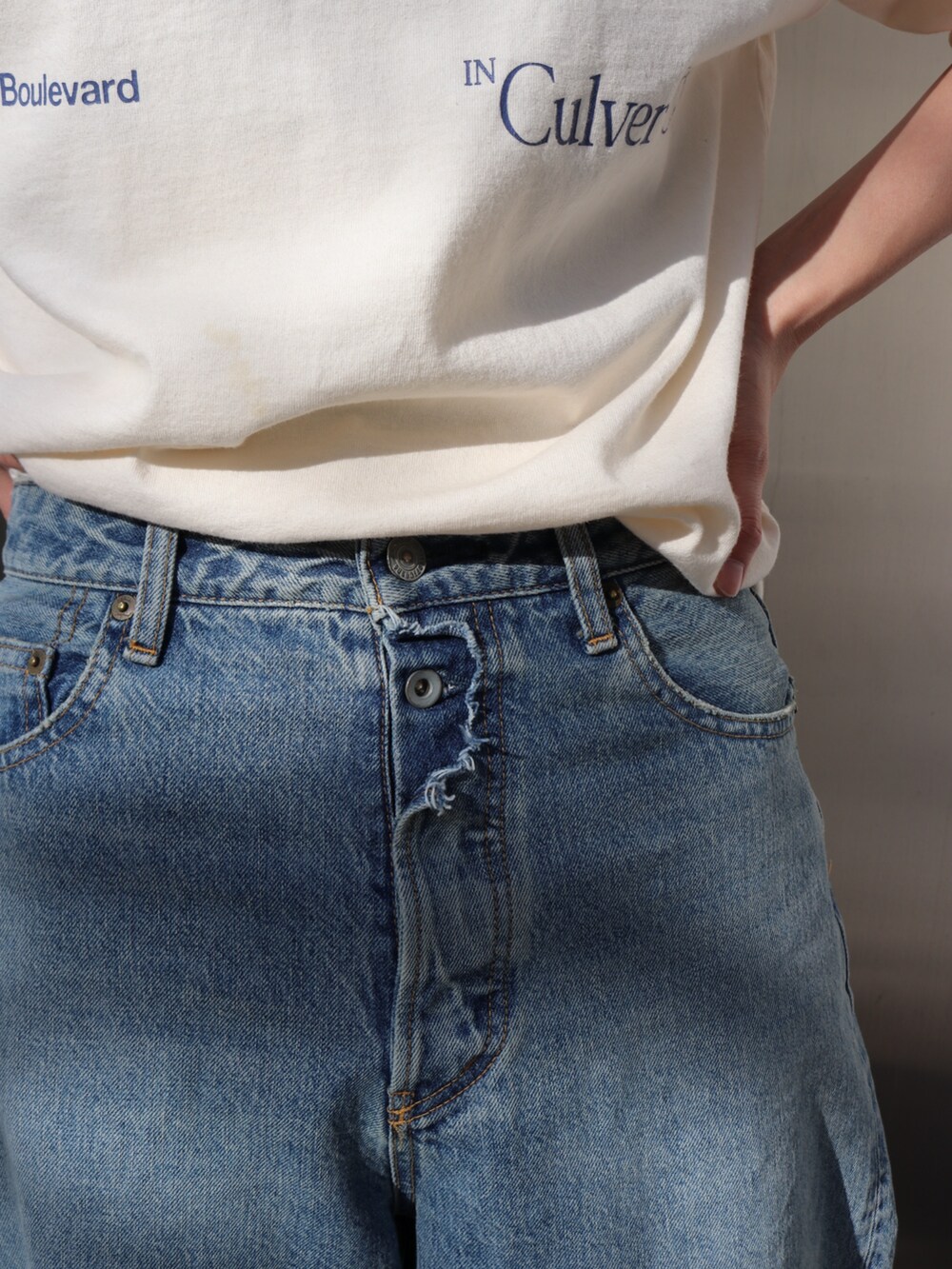 ホワイト系のTシャツ/カットソー、ブルー系のデニムパンツ、イエロー系のトートバッグを着用したレディースの春コーディネートの7枚目の写真