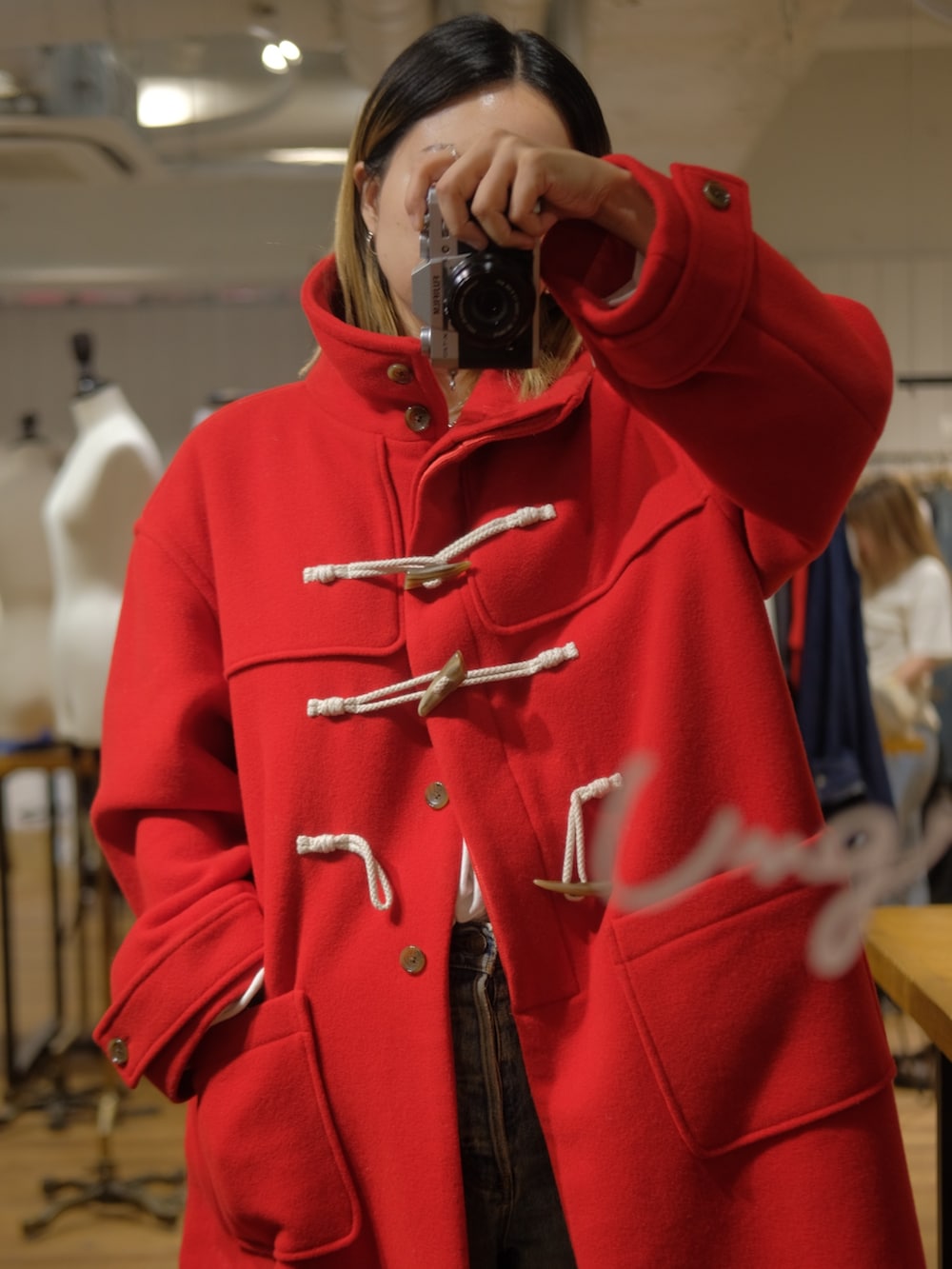 レッド系のダッフルコートを着用したレディースの秋コーディネートの2枚目の写真