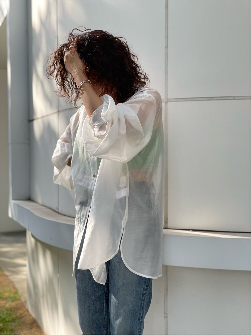 ホワイト系のシャツ/ブラウス、ブルー系のデニムパンツ、ブラック系のサンダルを着用したレディースの春コーディネートの5枚目の写真