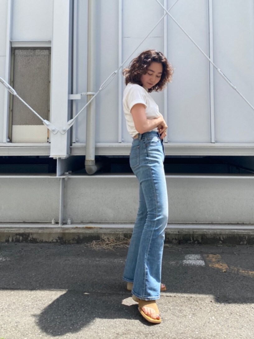 ブラウン系のサンダル、ブルー系のデニムパンツ、ホワイト系のTシャツ/カットソーを着用したレディースの春コーディネートの3枚目の写真