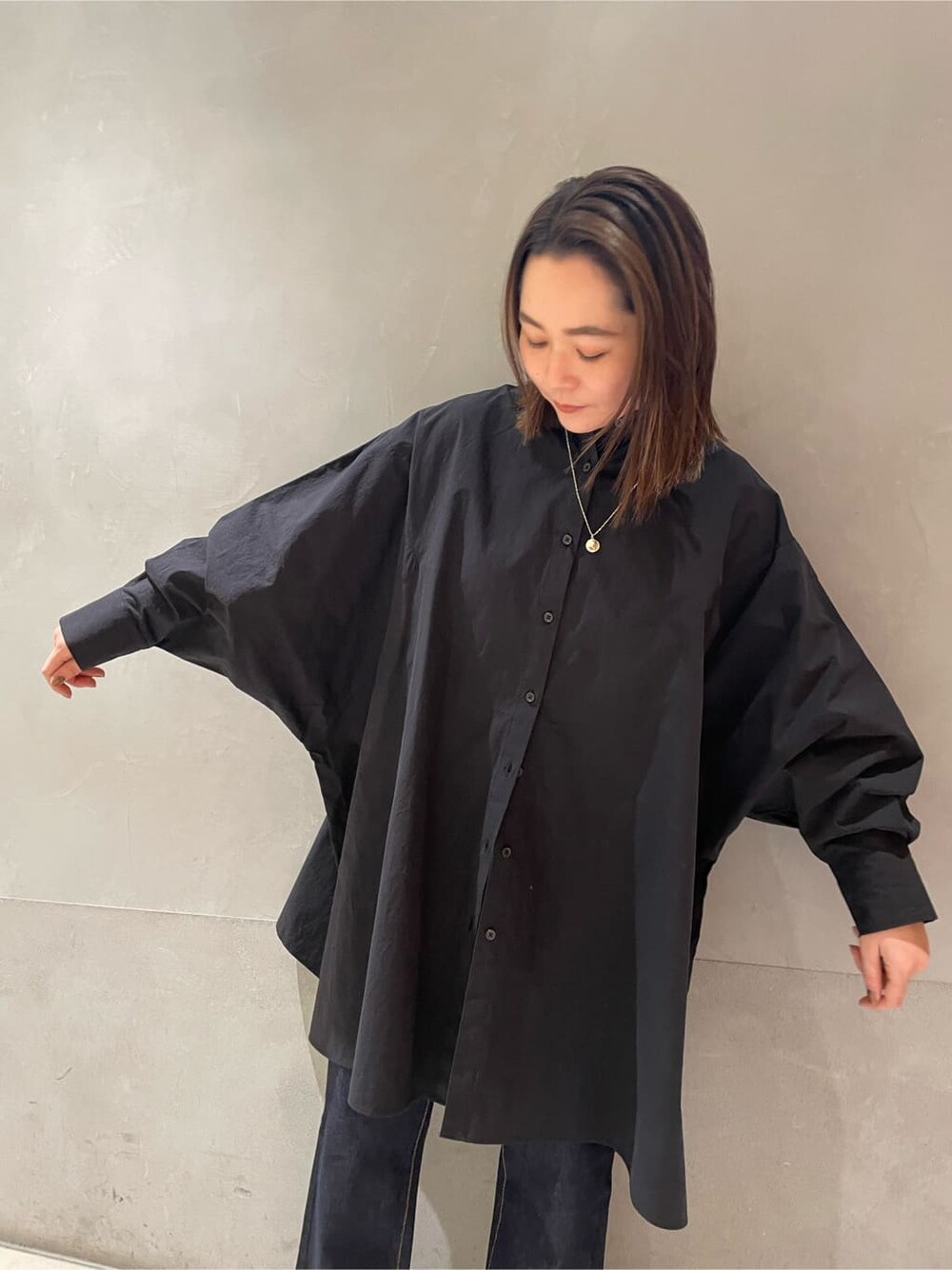 ブルー系のデニムパンツ、ブラック系のシャツ/ブラウスを着用したレディースの冬コーディネートの4枚目の写真