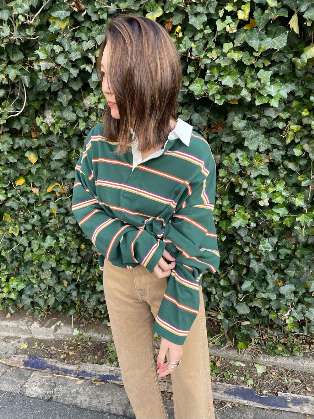 ベージュ系のデニムパンツ、グリーン系のTシャツ/カットソーを着用したレディースの冬コーディネートの3枚目の写真