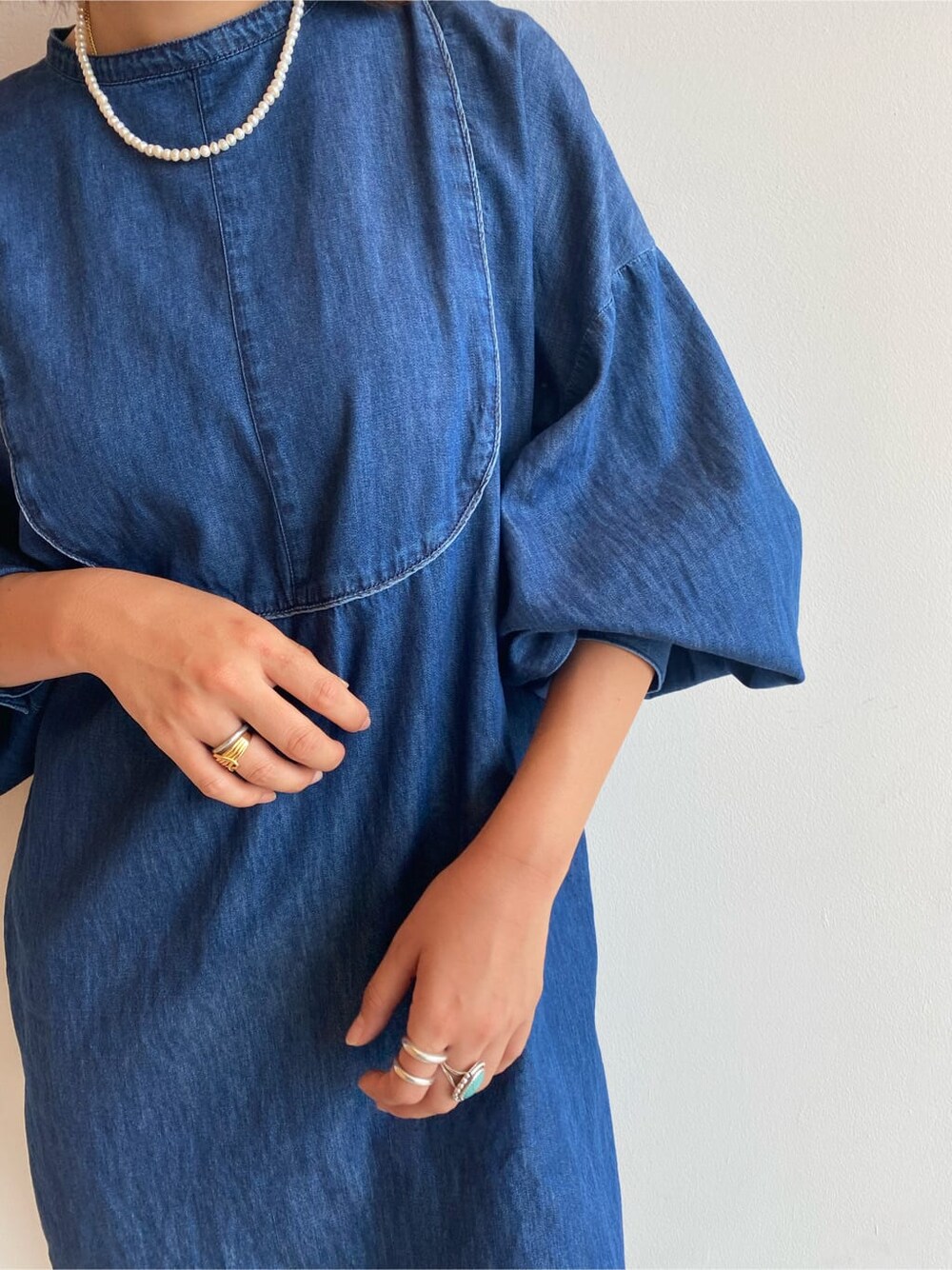 ブルー系のシャツ/ブラウス、ホワイト系のブーツ、ブルー系のデニムパンツを着用したレディースの夏コーディネートの6枚目の写真