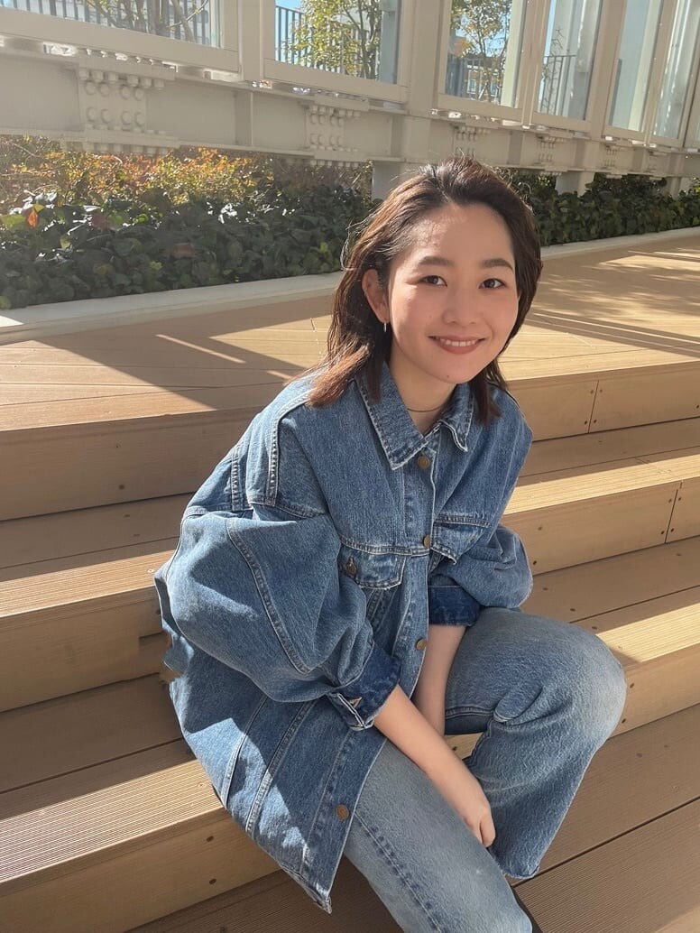 ブルー系のデニムジャケット、ピンク系のタンクトップを着用したレディースの冬コーディネートの8枚目の写真