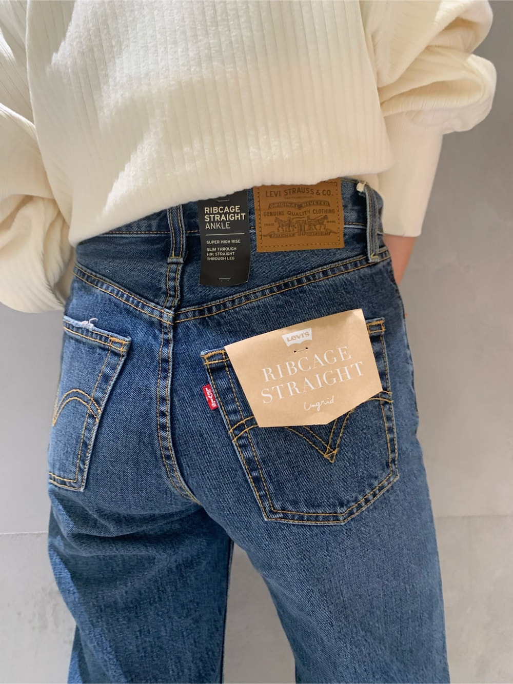 ブラック系のブーツ、ブルー系のデニムパンツ、ホワイト系のカーディガン/ボレロを着用したレディースの秋コーディネートの4枚目の写真