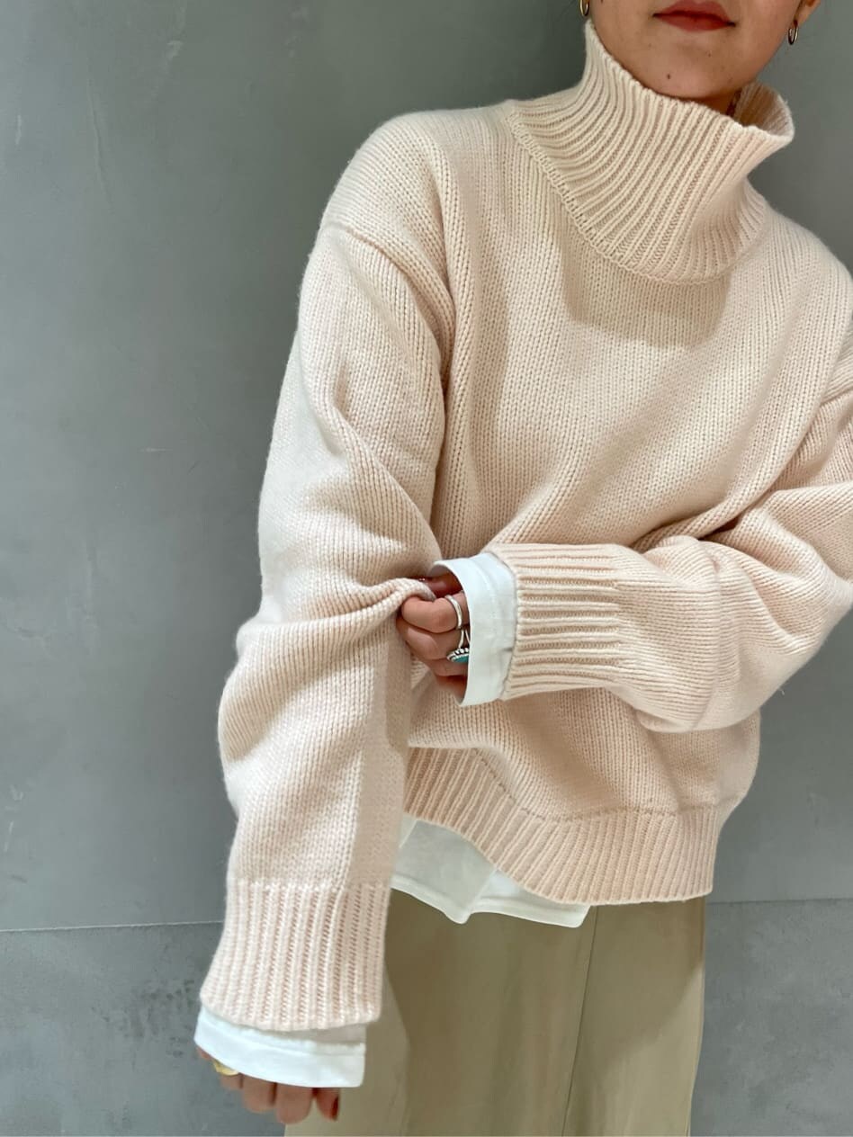 ホワイト系のダウンジャケット/コート、ベージュ系のスカート、ブラック系のブーツを着用したレディースの秋コーディネートの5枚目の写真