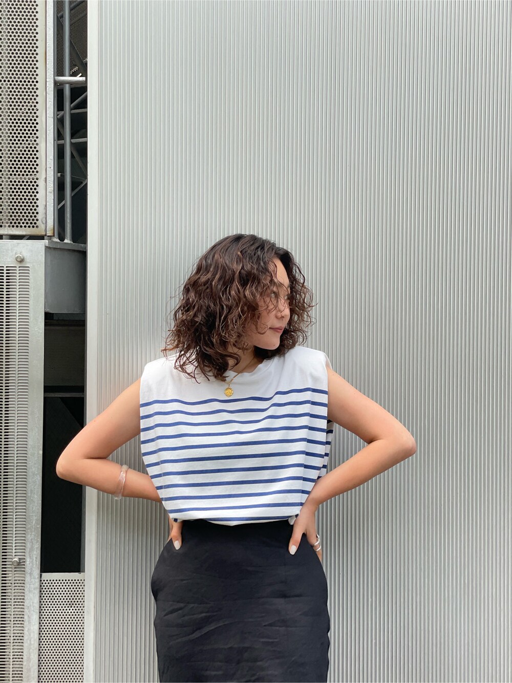 オレンジ系のサンダル、ブラック系のスカートを着用したレディースの春コーディネートの7枚目の写真