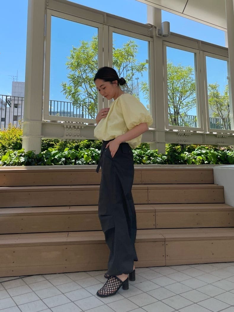 イエロー系のシャツ/ブラウス、ブラック系のサンダル、グレー系のその他パンツを着用したレディースの春コーディネートの3枚目の写真
