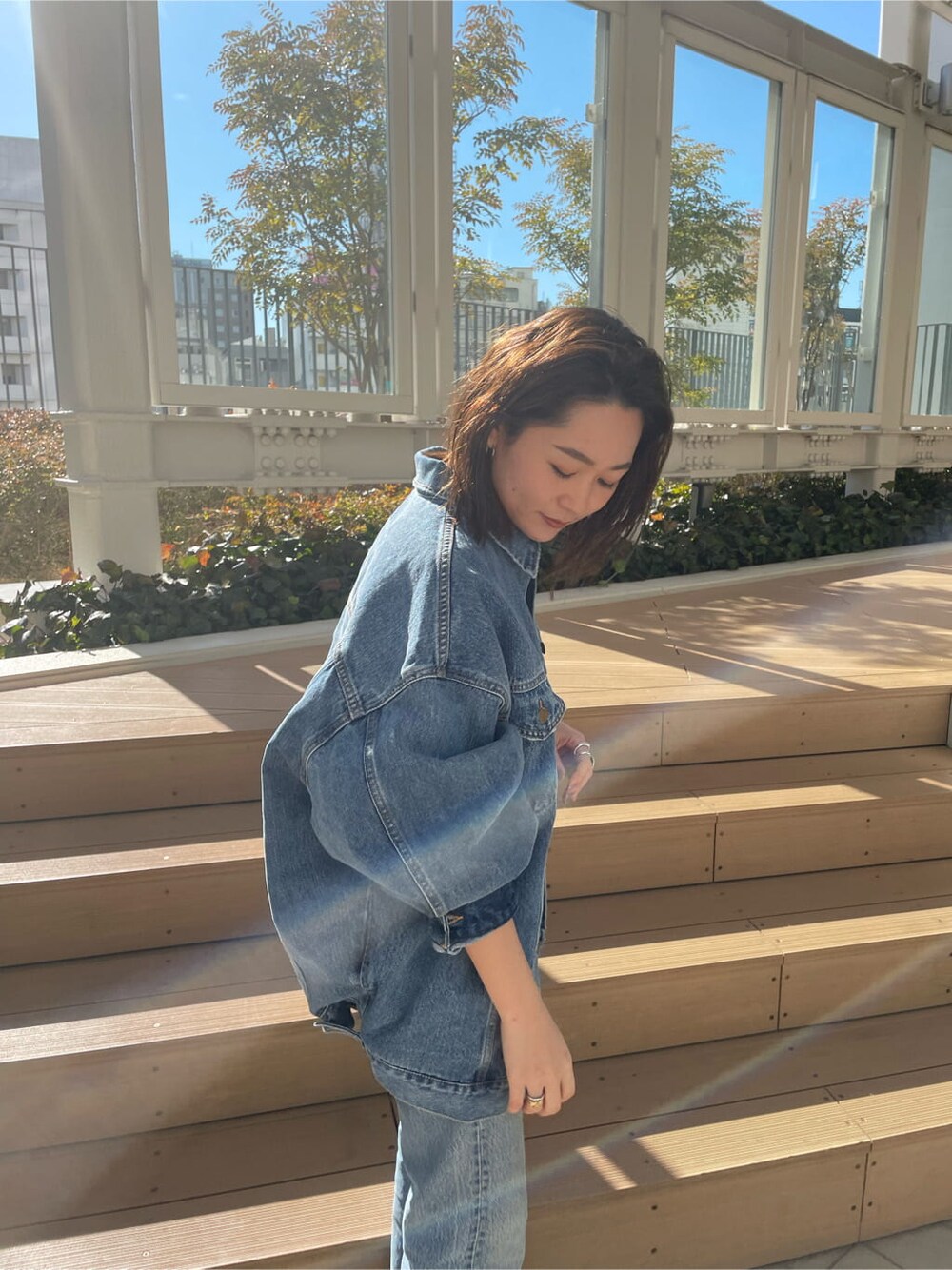 ブルー系のデニムジャケット、ピンク系のタンクトップを着用したレディースの冬コーディネートの4枚目の写真