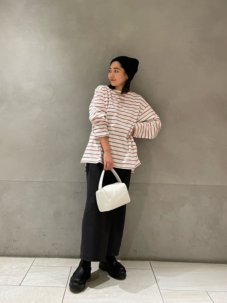 ピンク系のTシャツ/カットソー、グレー系のスカート、ホワイト系のハンドバッグを着用したレディースの冬コーディネートの3枚目の写真