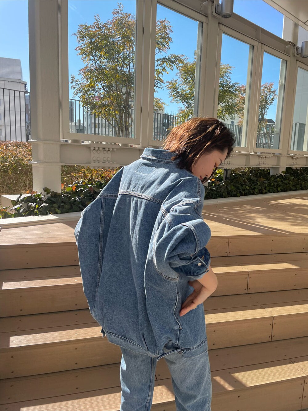 ブルー系のデニムジャケット、ピンク系のタンクトップを着用したレディースの冬コーディネートの5枚目の写真