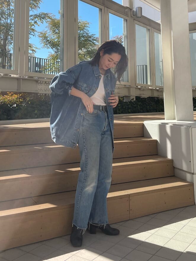 ブルー系のデニムジャケット、ピンク系のタンクトップを着用したレディースの冬コーディネートの2枚目の写真