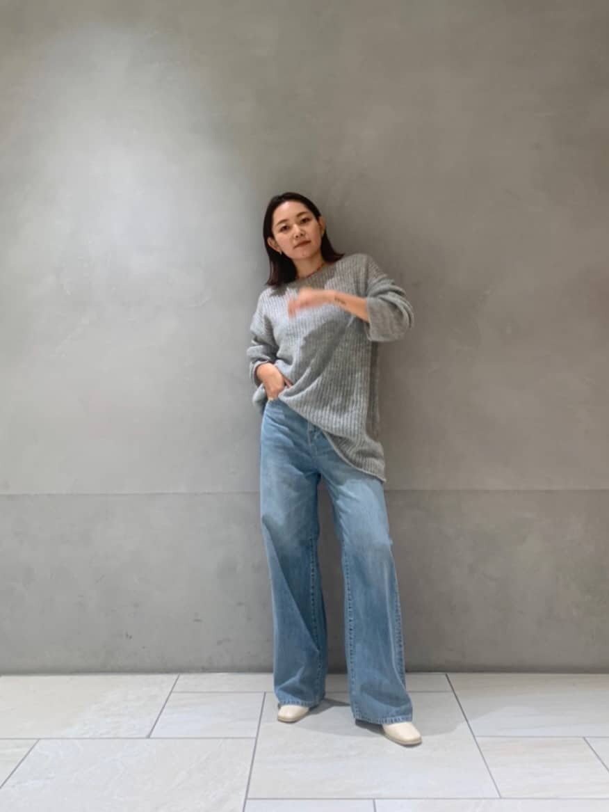 ホワイト系のブーツ、ブルー系のデニムパンツ、グレー系のニット/セーターを着用したレディースの秋コーディネートの3枚目の写真