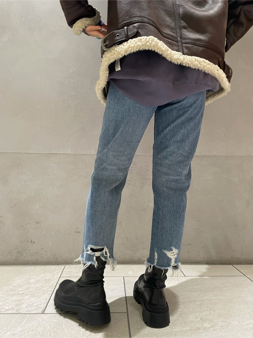 ブラウン系のブルゾン、ブルー系のデニムパンツ、ブルー系のスウェットを着用したレディースの秋コーディネートの7枚目の写真