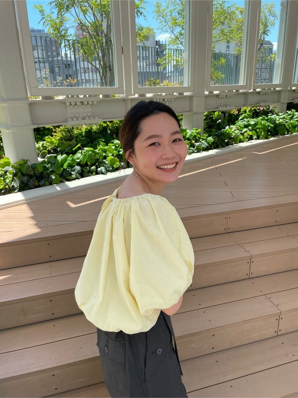 イエロー系のシャツ/ブラウス、ブラック系のサンダル、グレー系のその他パンツを着用したレディースの春コーディネートの4枚目の写真