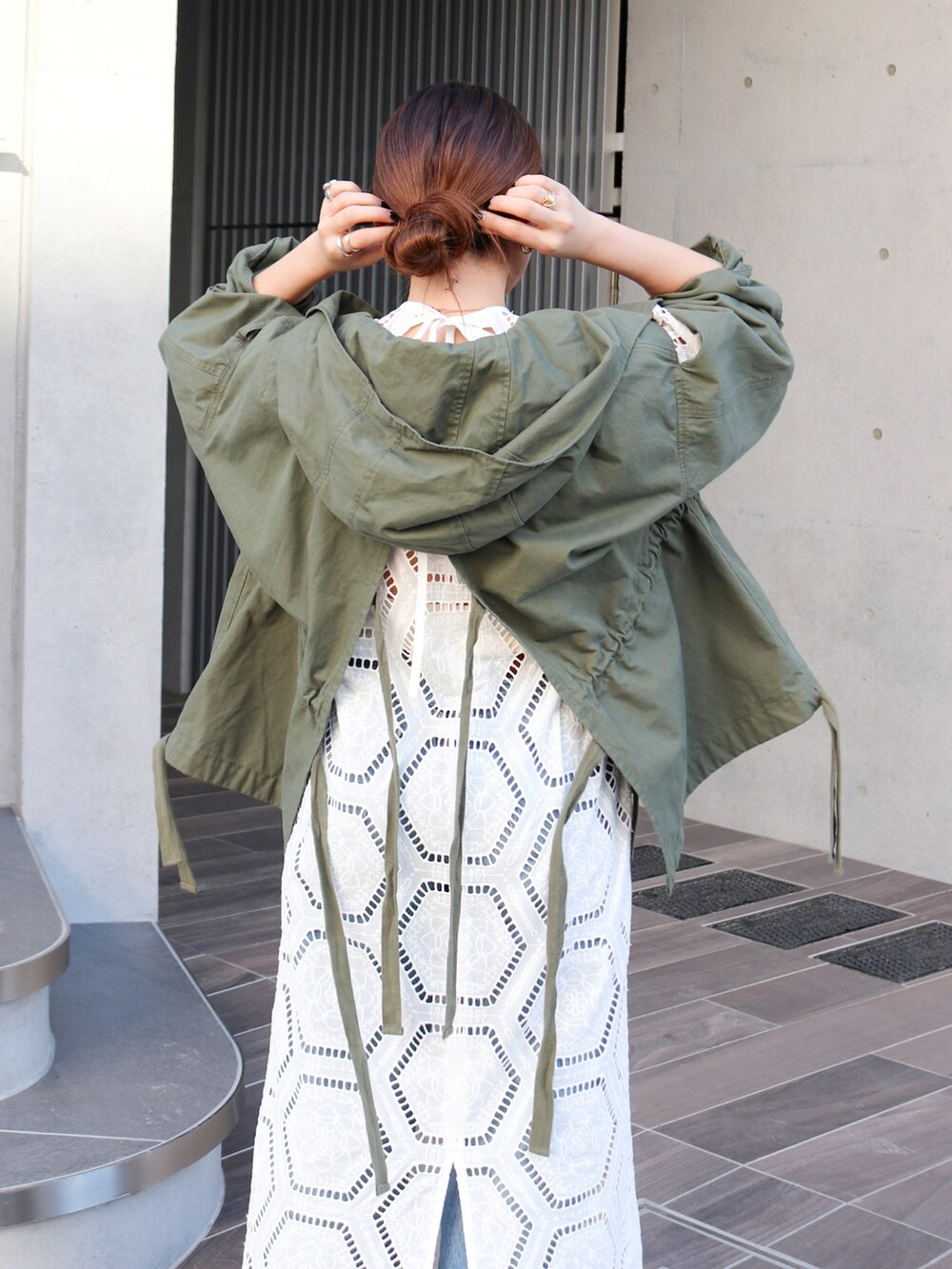 グリーン系のその他アウター、ホワイト系のワンピース、ブルー系のデニムパンツを着用したレディースの冬コーディネートの3枚目の写真