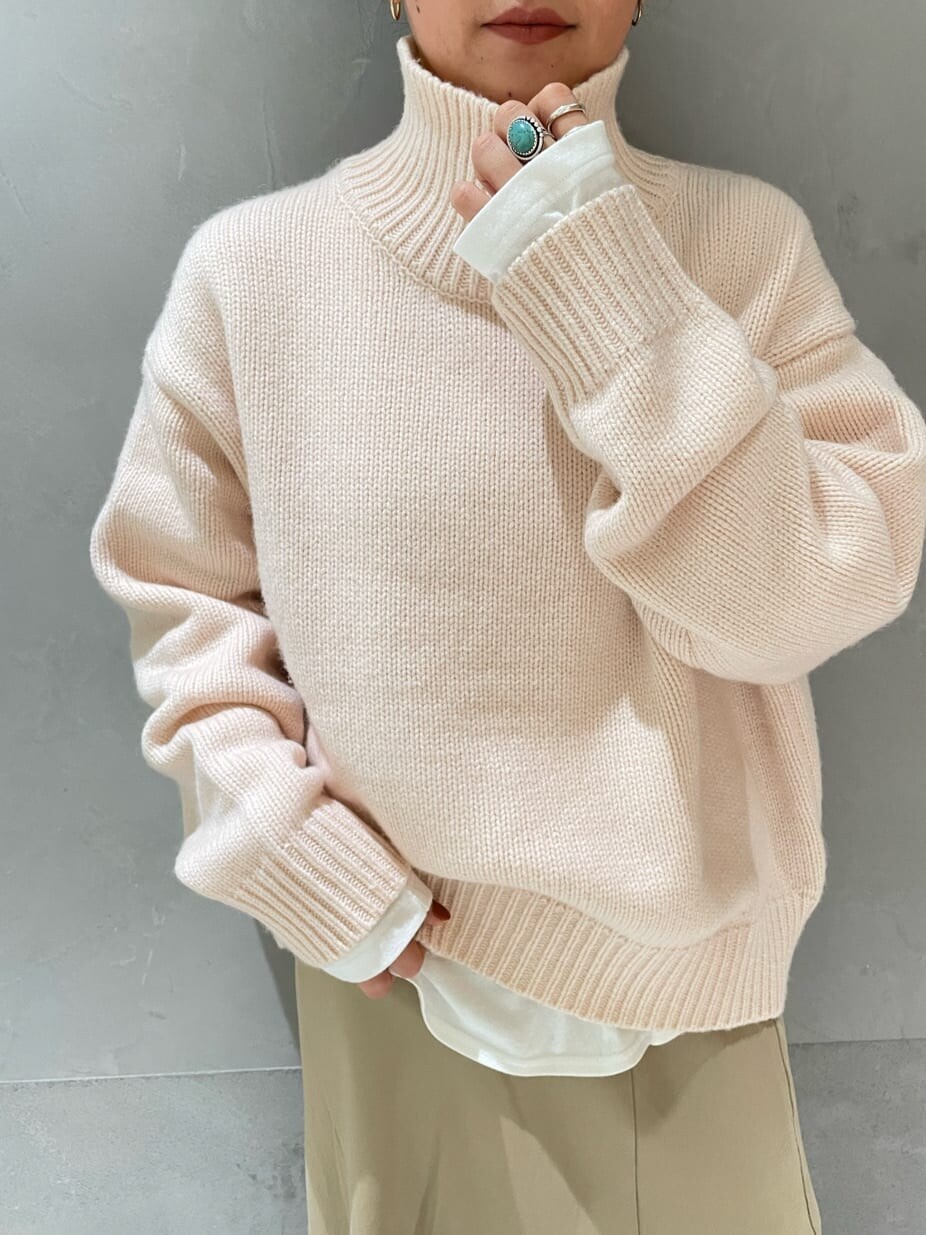 ホワイト系のダウンジャケット/コート、ベージュ系のスカート、ブラック系のブーツを着用したレディースの秋コーディネートの6枚目の写真