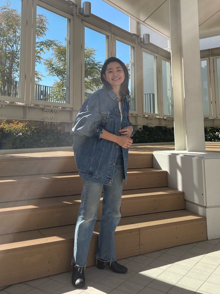 ブルー系のデニムジャケット、ピンク系のタンクトップを着用したレディースの冬コーディネートの3枚目の写真