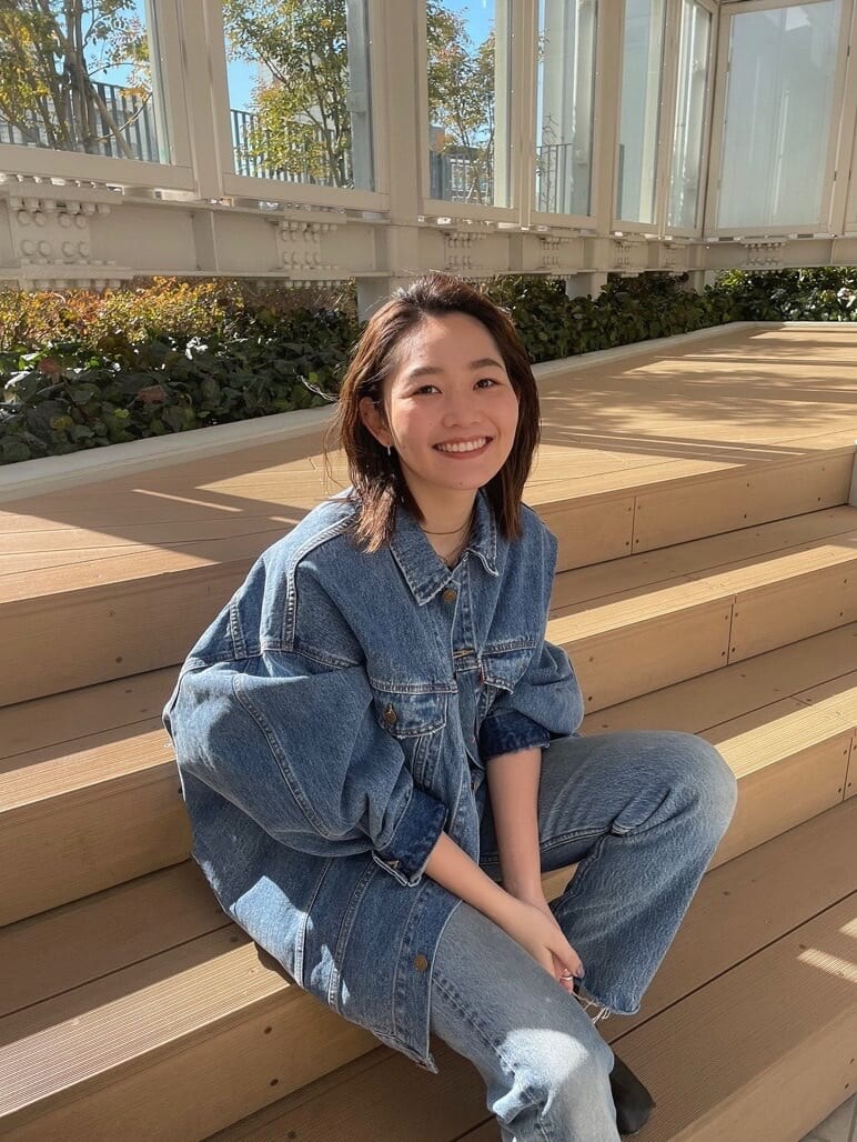 ブルー系のデニムジャケット、ピンク系のタンクトップを着用したレディースの冬コーディネートの6枚目の写真