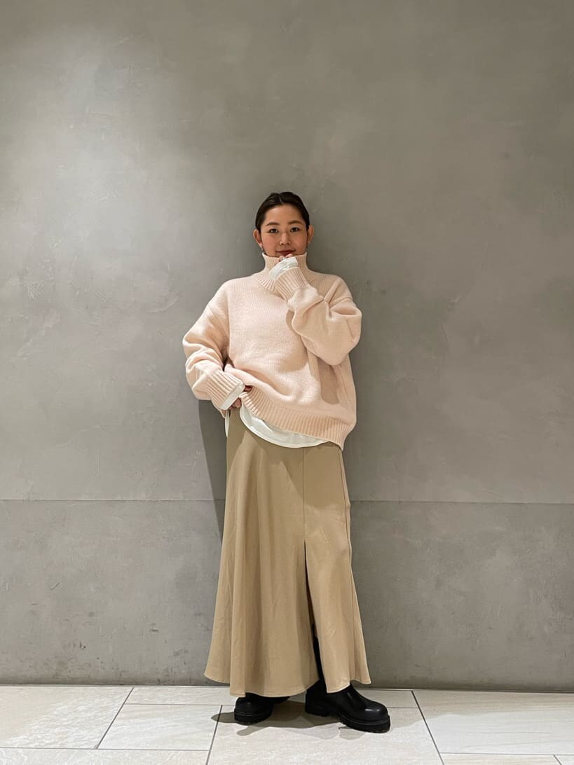 ホワイト系のダウンジャケット/コート、ベージュ系のスカート、ブラック系のブーツを着用したレディースの秋コーディネートの4枚目の写真