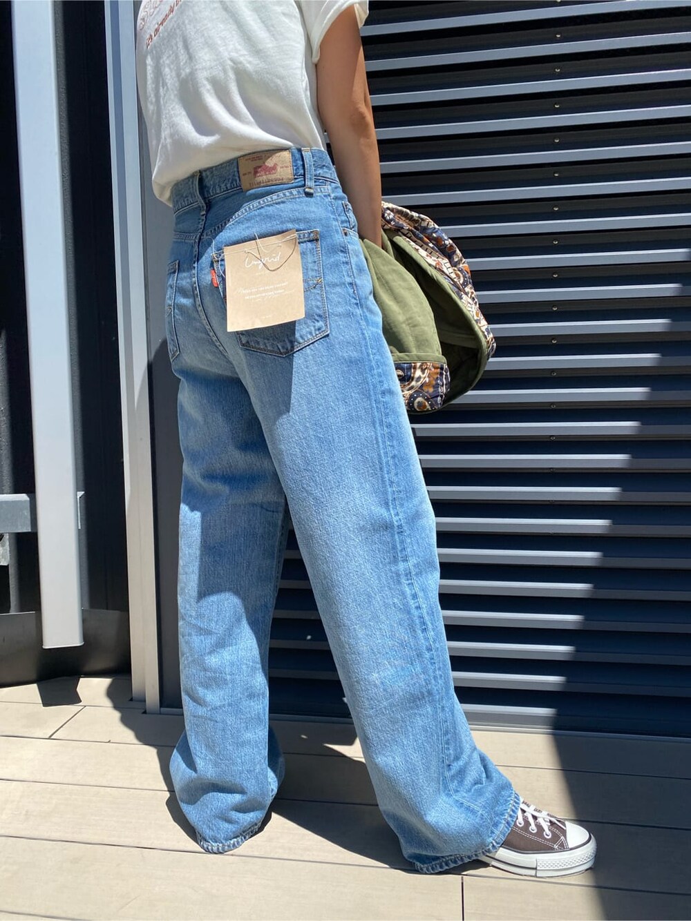 ベージュ系のブルゾン、ブルー系のデニムパンツ、ホワイト系のTシャツ/カットソーを着用したレディースの夏コーディネートの5枚目の写真