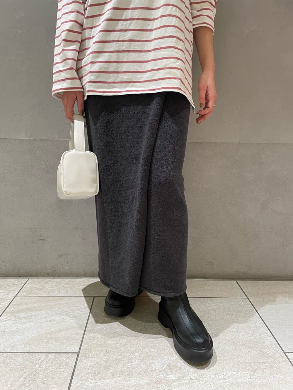 ピンク系のTシャツ/カットソー、グレー系のスカート、ホワイト系のハンドバッグを着用したレディースの冬コーディネートの5枚目の写真