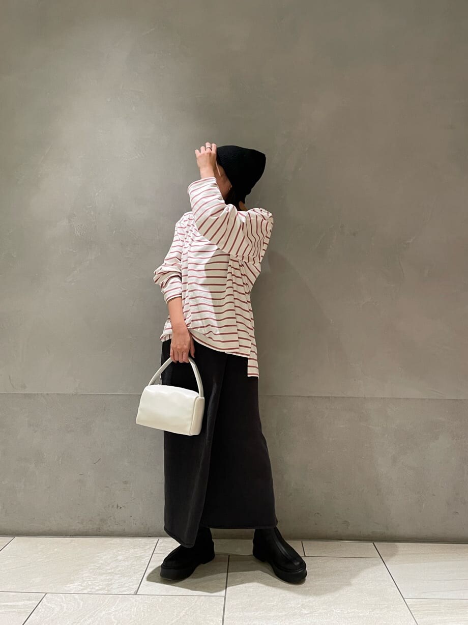 ピンク系のTシャツ/カットソー、グレー系のスカート、ホワイト系のハンドバッグを着用したレディースの冬コーディネートの2枚目の写真
