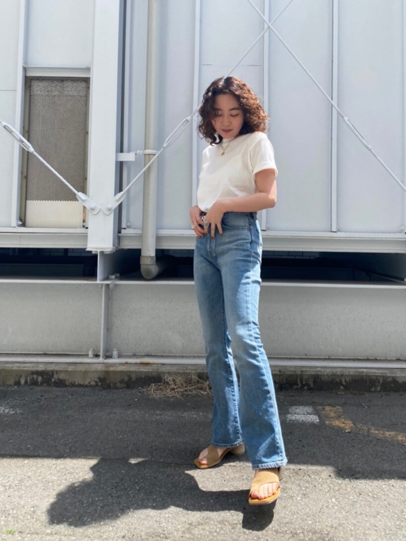 ブラウン系のサンダル、ブルー系のデニムパンツ、ホワイト系のTシャツ/カットソーを着用したレディースの春コーディネートの2枚目の写真