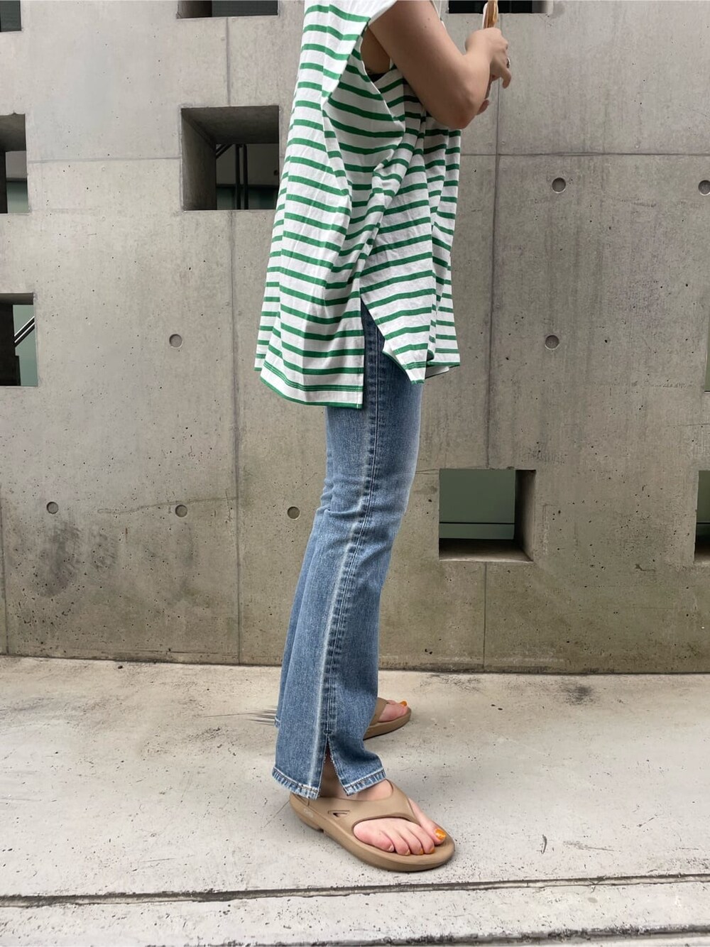 ブルー系のデニムパンツを着用したレディースの夏コーディネートの2枚目の写真