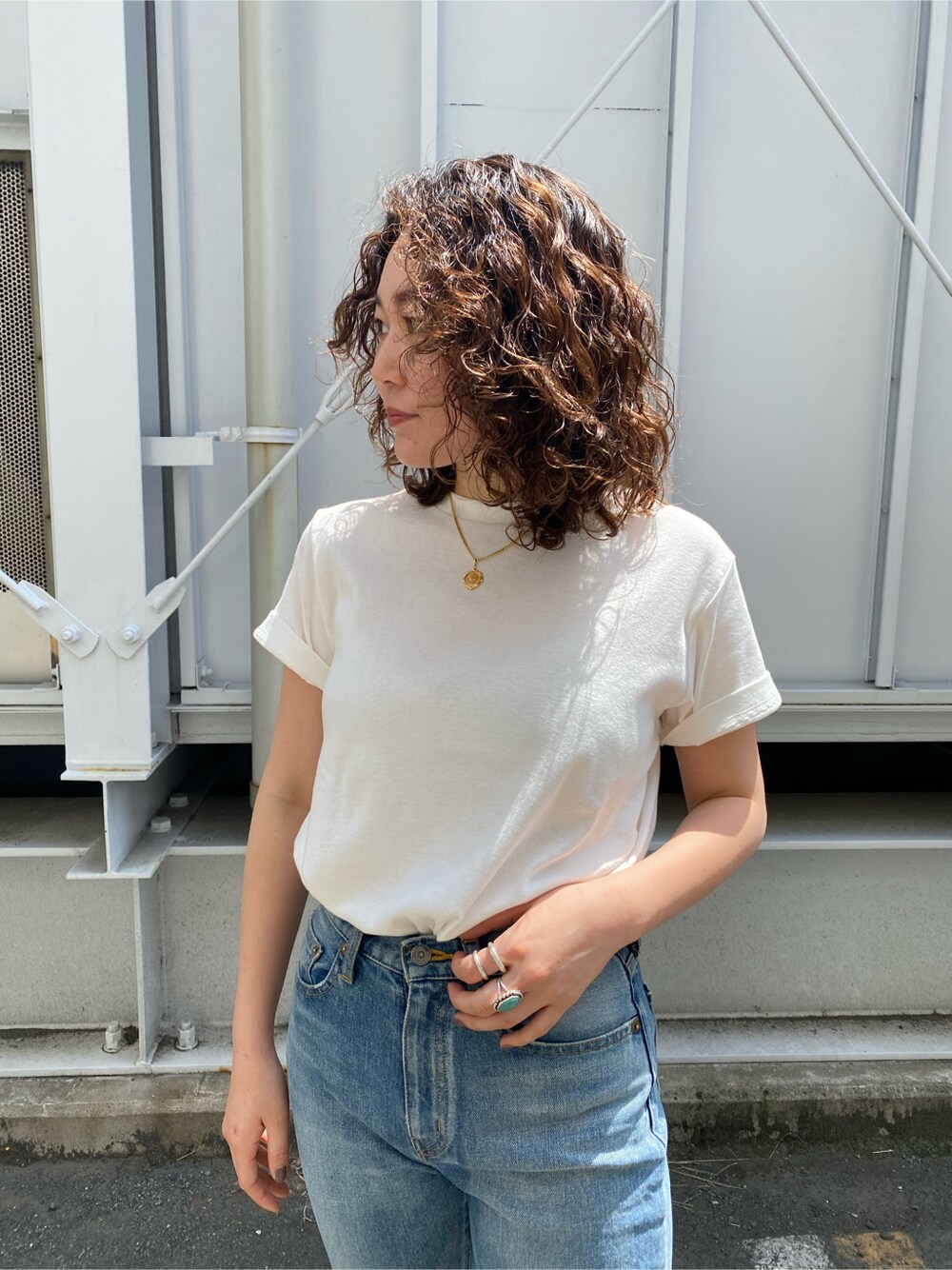 ブラウン系のサンダル、ブルー系のデニムパンツ、ホワイト系のTシャツ/カットソーを着用したレディースの春コーディネートの4枚目の写真