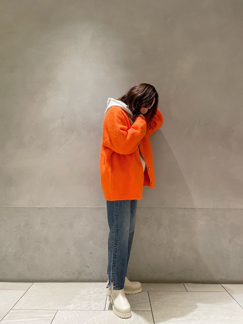 ブルー系のデニムパンツ、グレー系のパーカー、オレンジ系のカーディガン/ボレロを着用したレディースの冬コーディネートの4枚目の写真