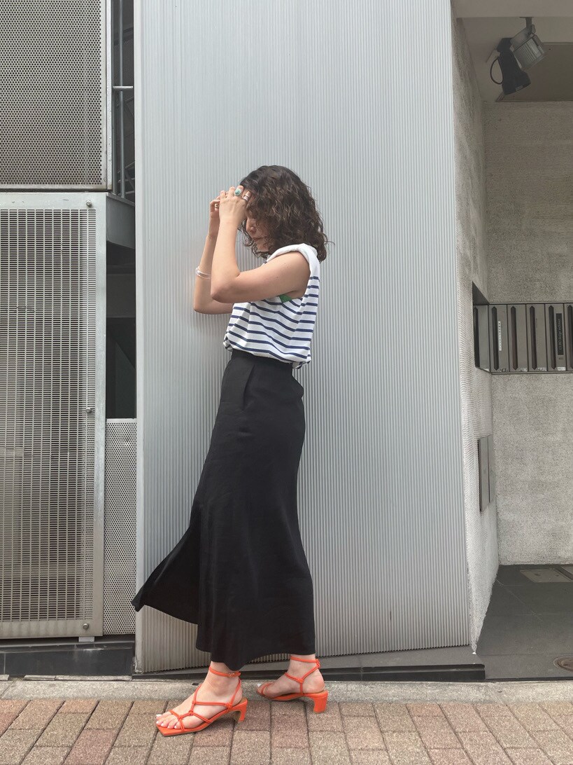 オレンジ系のサンダル、ブラック系のスカートを着用したレディースの春コーディネートの3枚目の写真