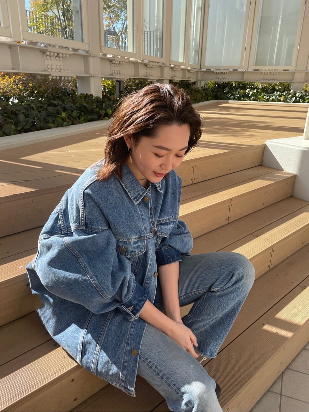 ブルー系のデニムジャケット、ピンク系のタンクトップを着用したレディースの冬コーディネートの7枚目の写真