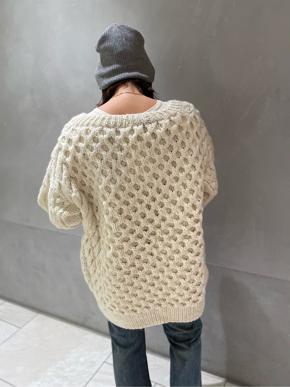 グレー系のTシャツ/カットソー、ブルー系のデニムパンツ、ホワイト系のカーディガン/ボレロを着用したレディースの秋コーディネートの4枚目の写真