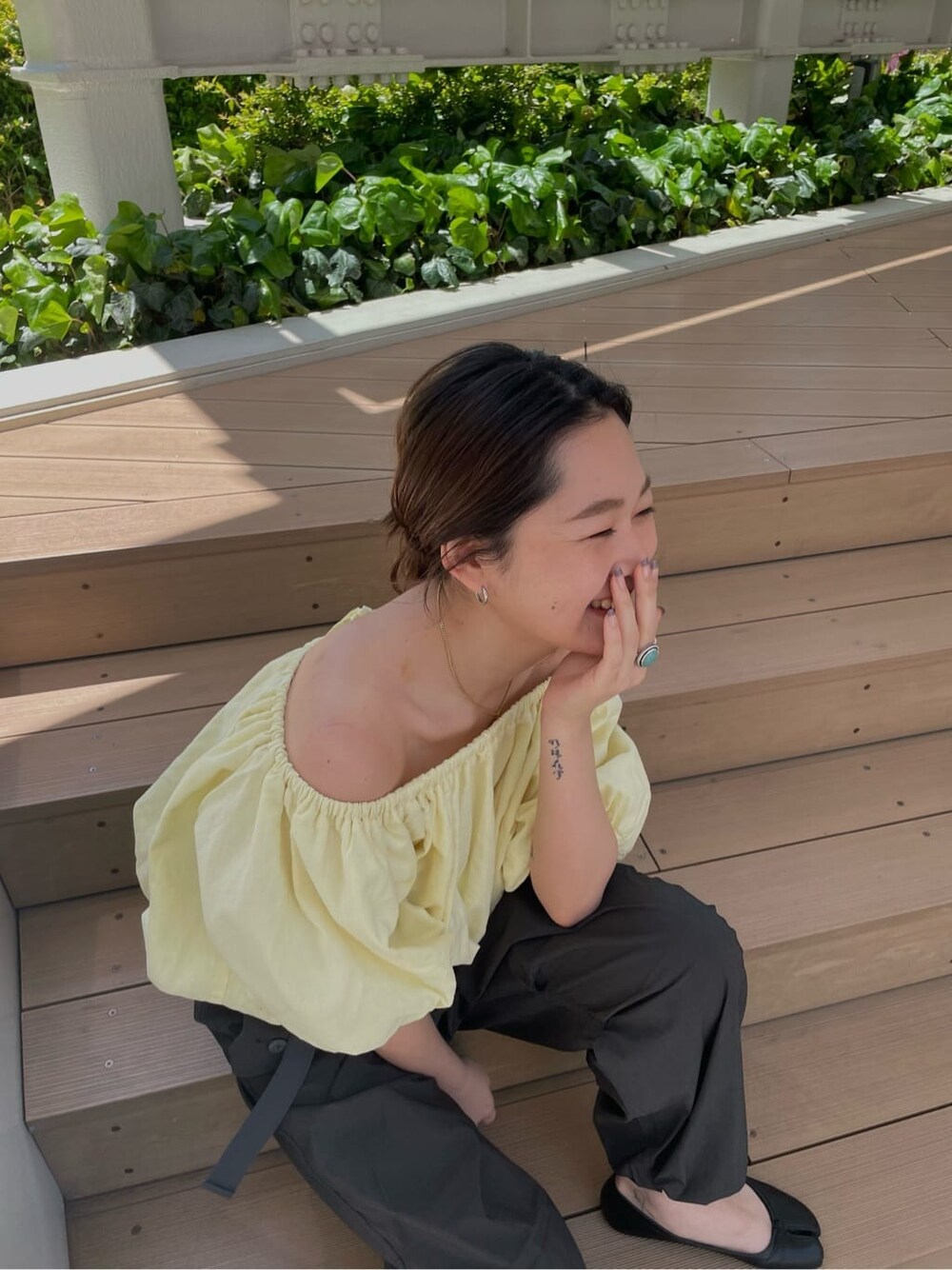 イエロー系のシャツ/ブラウス、ブラック系のサンダル、グレー系のその他パンツを着用したレディースの春コーディネートの5枚目の写真