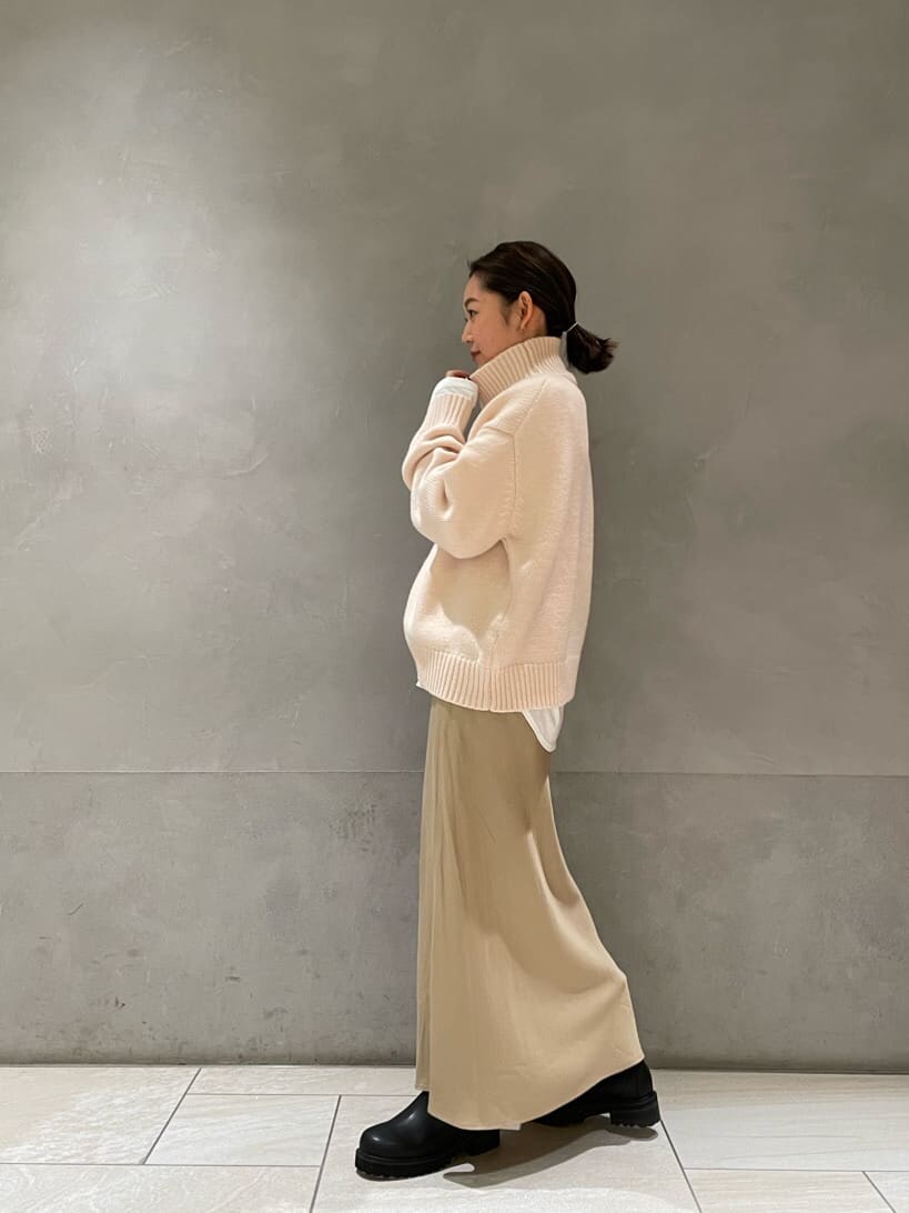 ホワイト系のダウンジャケット/コート、ベージュ系のスカート、ブラック系のブーツを着用したレディースの秋コーディネートの3枚目の写真