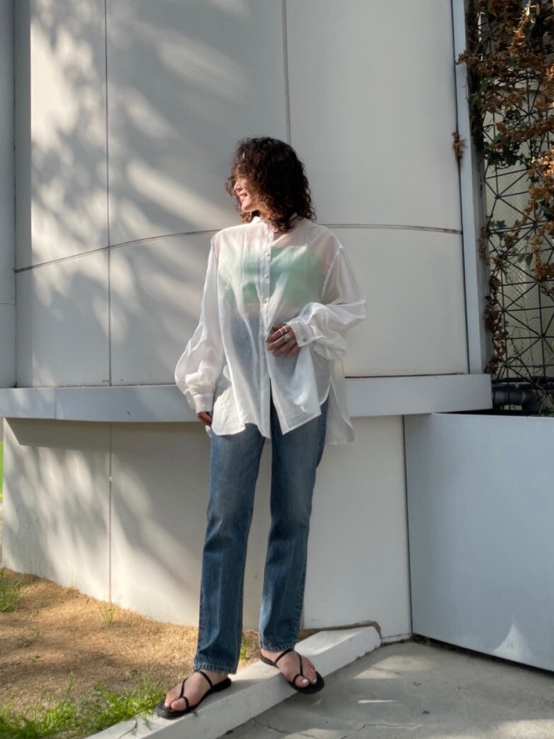 ホワイト系のシャツ/ブラウス、ブルー系のデニムパンツ、ブラック系のサンダルを着用したレディースの春コーディネートの3枚目の写真