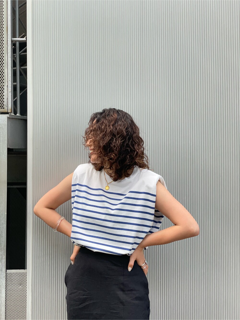 オレンジ系のサンダル、ブラック系のスカートを着用したレディースの春コーディネートの6枚目の写真