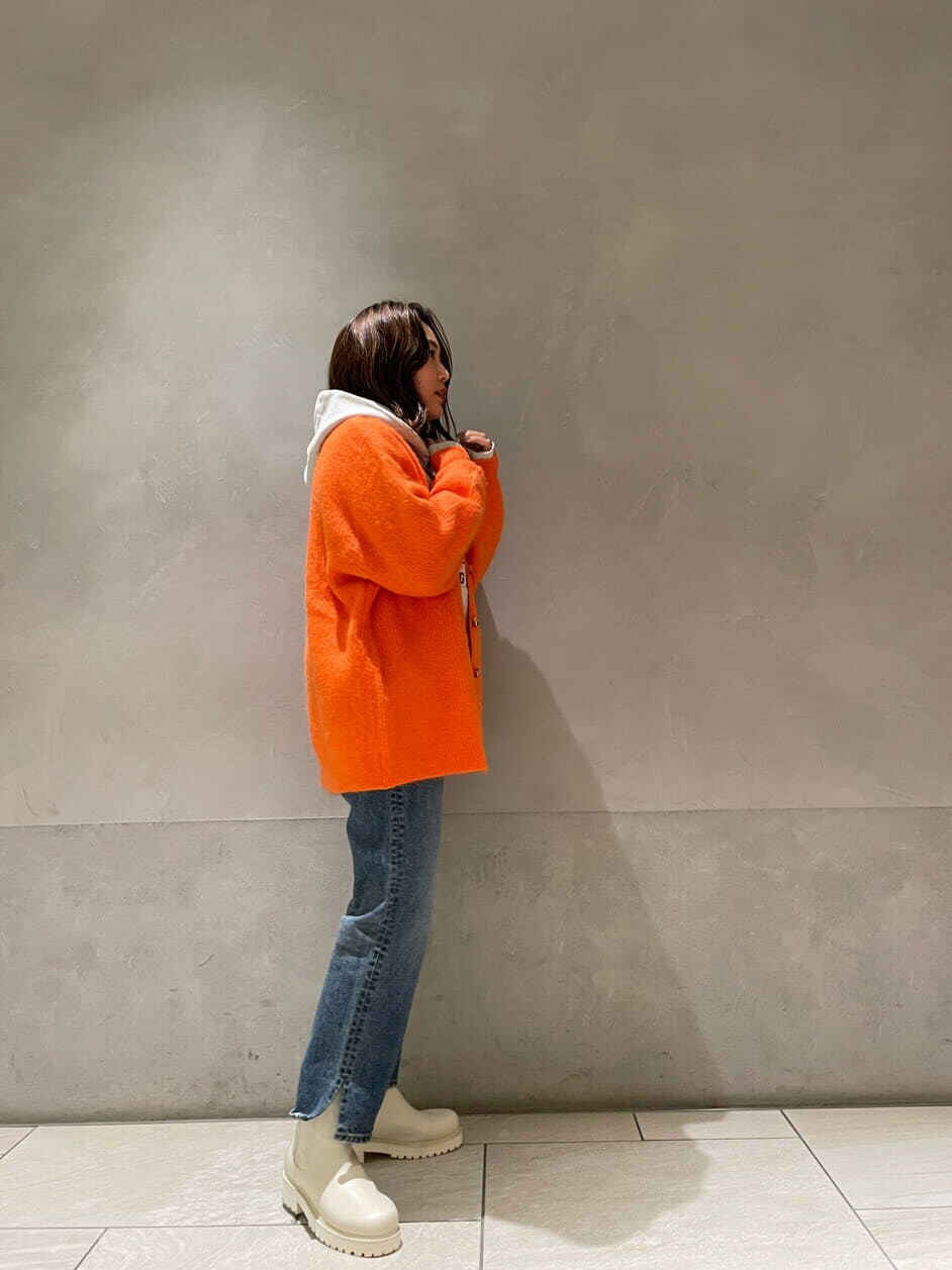 ブルー系のデニムパンツ、グレー系のパーカー、オレンジ系のカーディガン/ボレロを着用したレディースの冬コーディネートの3枚目の写真