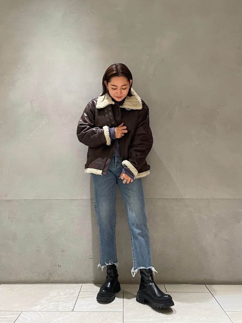 ブラウン系のブルゾン、ブルー系のデニムパンツ、ブルー系のスウェットを着用したレディースの秋コーディネートの4枚目の写真