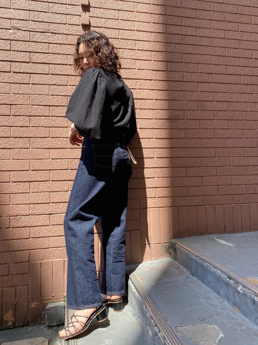 ブラック系のシャツ/ブラウス、ブルー系のデニムパンツを着用したレディースの春コーディネートの2枚目の写真