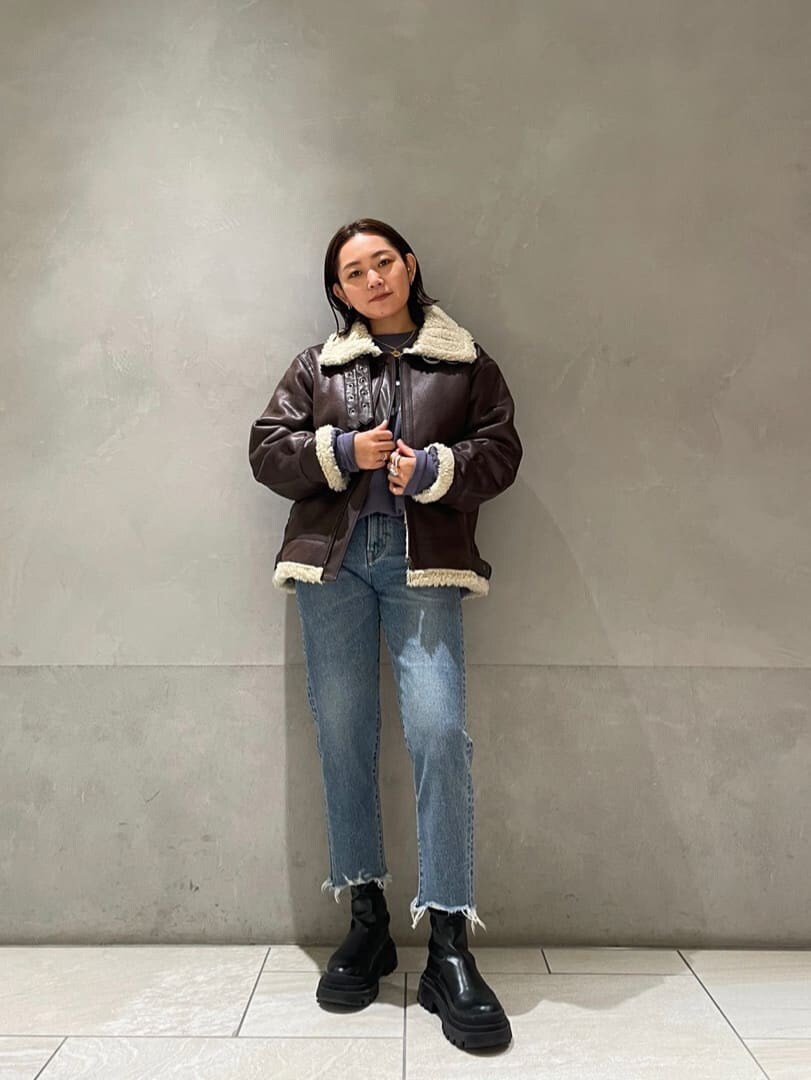 ブラウン系のブルゾン、ブルー系のデニムパンツ、ブルー系のスウェットを着用したレディースの秋コーディネートの3枚目の写真