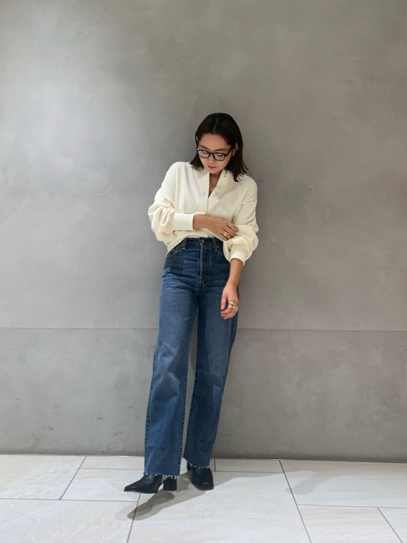 ブラック系のブーツ、ブルー系のデニムパンツ、ホワイト系のカーディガン/ボレロを着用したレディースの秋コーディネートの3枚目の写真