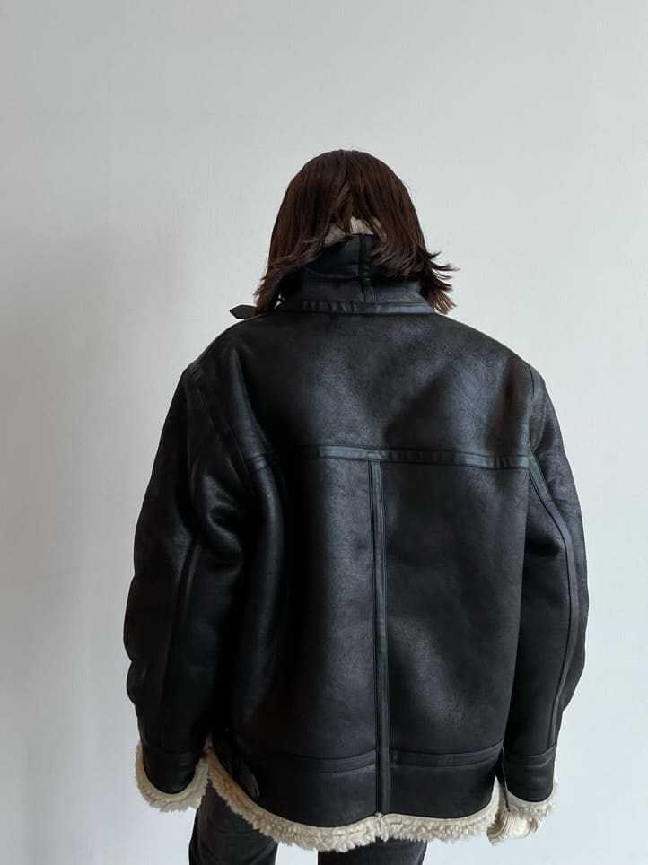 ブラック系のブルゾン、ブラウン系のブーツ、ブラック系のデニムパンツを着用したレディースの秋コーディネートの7枚目の写真