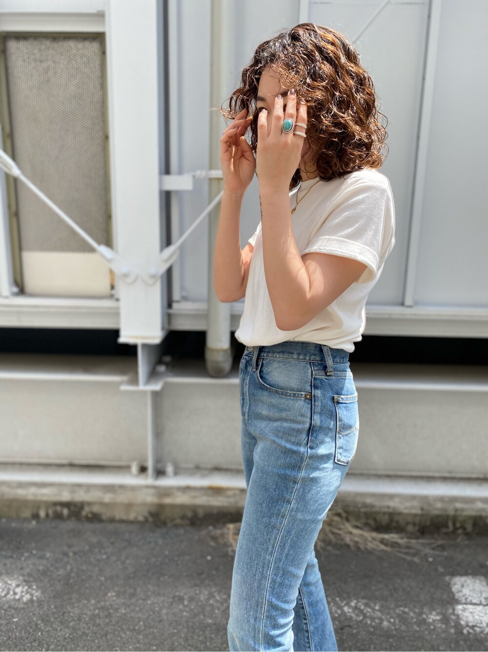 ブラウン系のサンダル、ブルー系のデニムパンツ、ホワイト系のTシャツ/カットソーを着用したレディースの春コーディネートの5枚目の写真