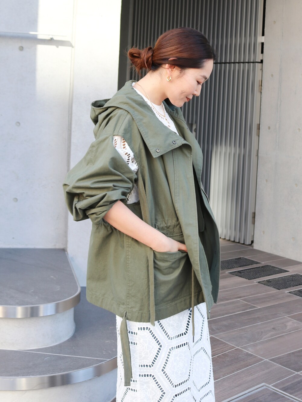 グリーン系のその他アウター、ホワイト系のワンピース、ブルー系のデニムパンツを着用したレディースの冬コーディネートの4枚目の写真