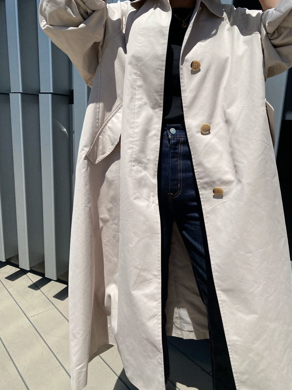 ブラック系のTシャツ/カットソー、ホワイト系のステンカラーコート、ブルー系のデニムパンツを着用したレディースの夏コーディネートの3枚目の写真