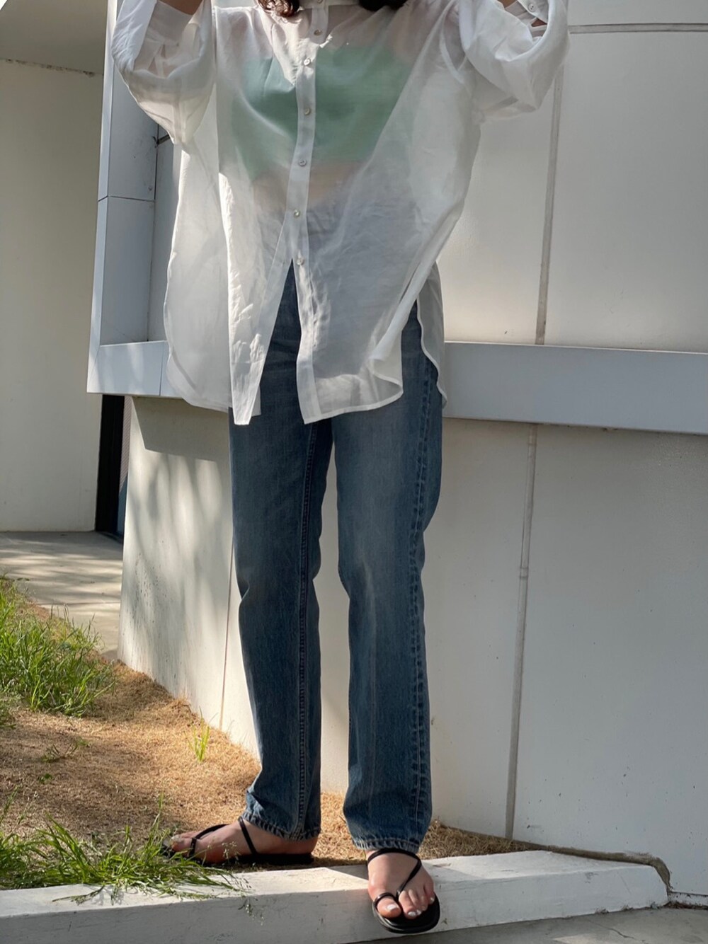 ホワイト系のシャツ/ブラウス、ブルー系のデニムパンツ、ブラック系のサンダルを着用したレディースの春コーディネートの4枚目の写真